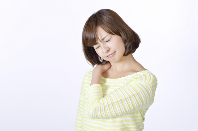 寝違えに悩む女性の写真